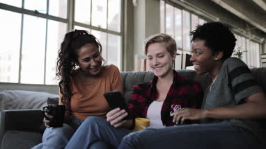 Young adult friends socialising whilst on their smartphones