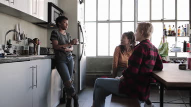 Young adult friends having coffee together in loft apartment