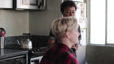 Female couple having coffee together in loft apartment