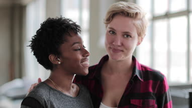 Portrait of young lesbian couple in loft apartment