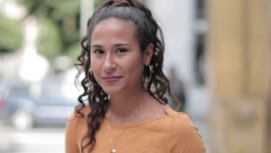 Portrait of hispanic young adult female on busy city street